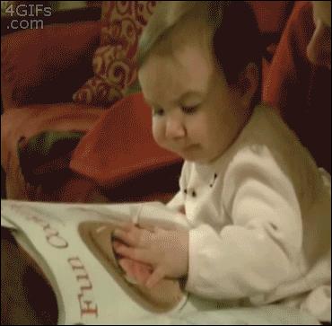 baby tries to eat food from a magazine